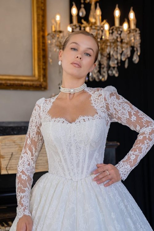Richmond TX Custom Wedding Dress - Close-up portrait of a bride looking upward in a long-sleeved lace ballgown with a sweetheart neckline and pearl choker.